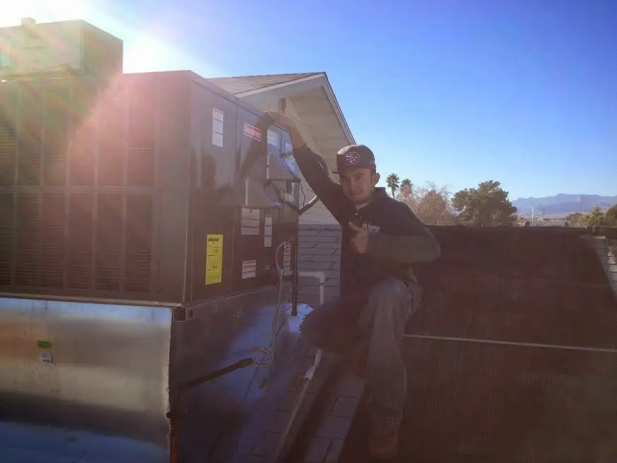 HVAC technician performing Boiler Repair on a rooftop unit in Lenox